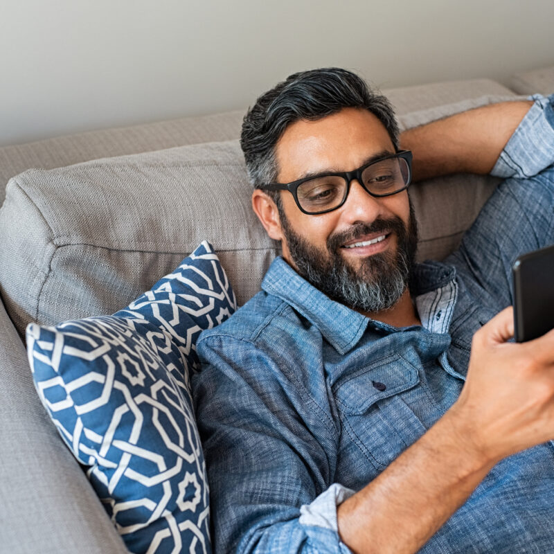 man on phone searching for healthcare price transparency at home