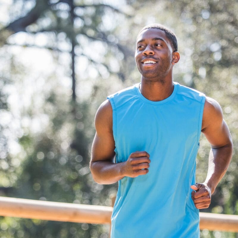 Man jogging next to country fence